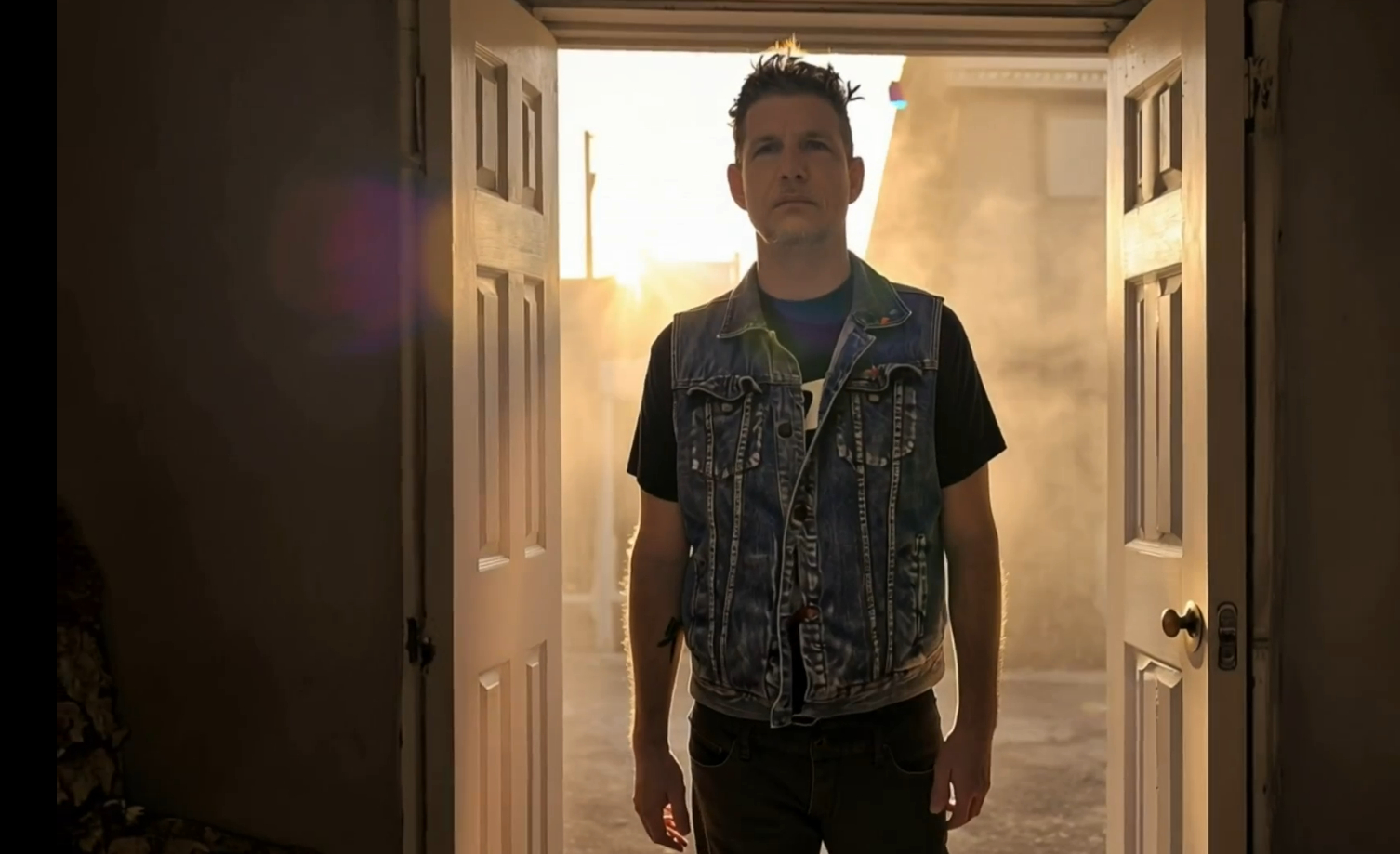 Jason Russo standing in a dark hallway, lit dramatically from behind